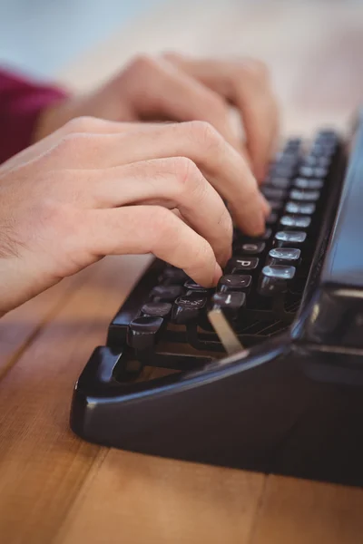Uomo che utilizza la macchina da scrivere alla scrivania in ufficio — Foto Stock