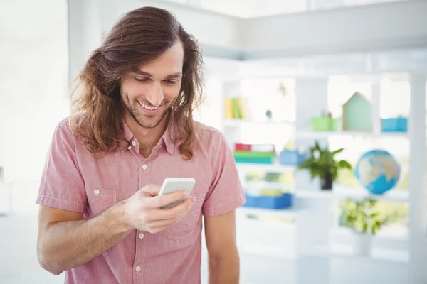 Hipster lächelt beim Blick aufs Handy — Stockfoto