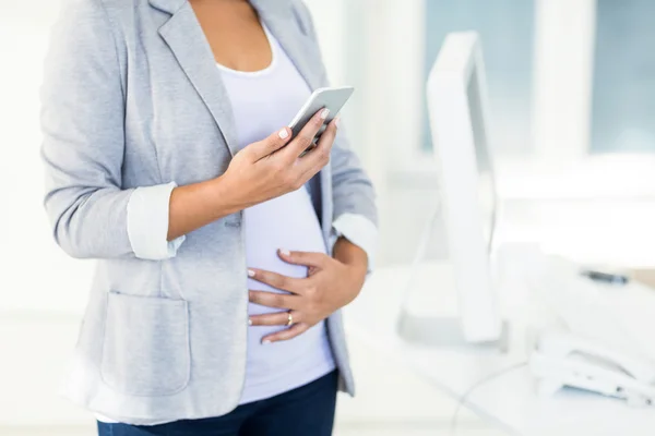 Donna d'affari incinta utilizzando il telefono — Foto Stock