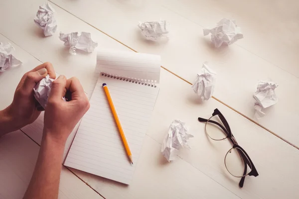 Manos arrugando papel sobre escritorio de madera —  Fotos de Stock