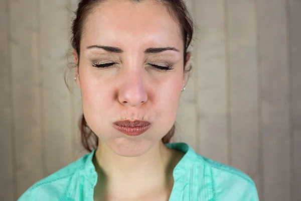 Close-up of woman with eyes closed while making face — Stock Photo, Image