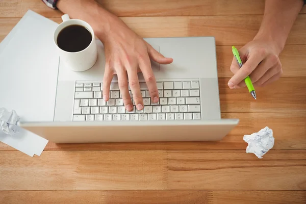 Homme avec café et stylo travaillant sur ordinateur portable — Photo