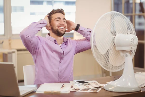 Relaxați-vă omul de afaceri așezat de ventilator electric — Fotografie, imagine de stoc