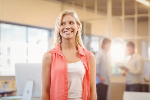 Empresaria mirando hacia otro lado mientras está de pie en contra de colega masculino — Foto de Stock