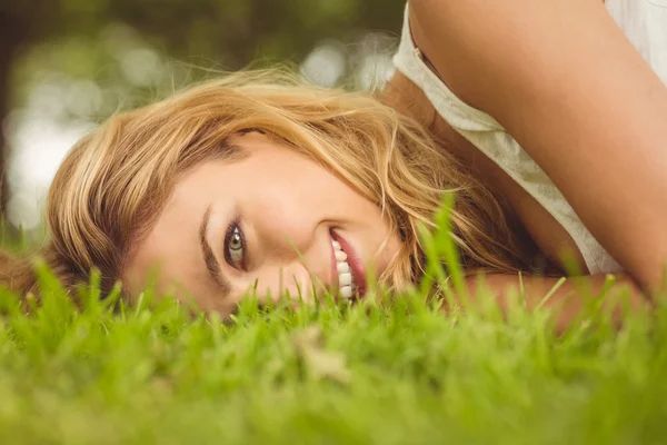 Portret pięknej kobiety uśmiechający się leżąc na trawie — Zdjęcie stockowe