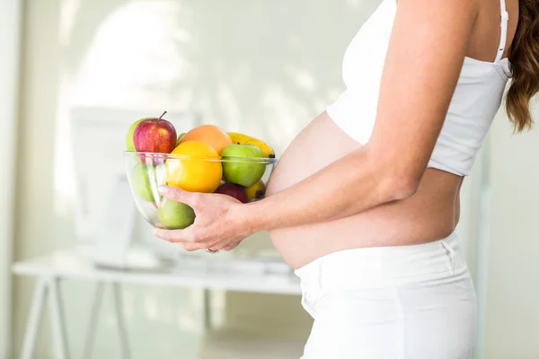 Vista lateral de la mujer sosteniendo frutero — Foto de Stock