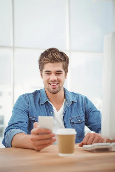 Feliz hipster sorrindo enquanto olha para o telefone móvel — Fotografia de Stock