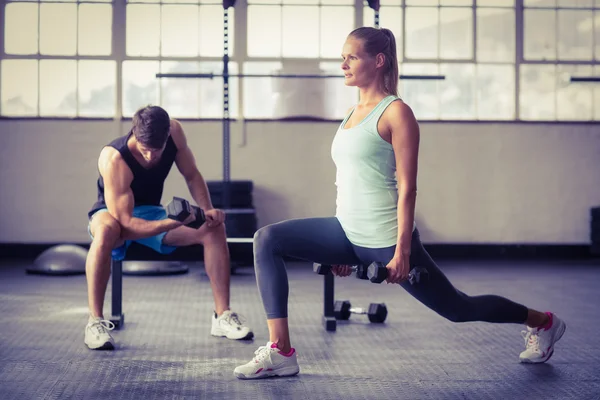 Pareja seria haciendo ejercicio con pesas — Foto de Stock