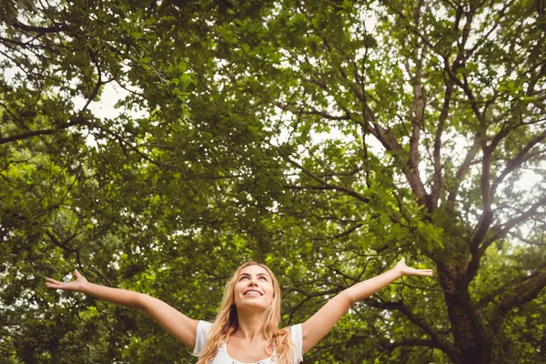 Happy woman with arms raised in park — Stock Photo, Image