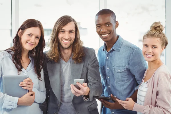 Retrato da equipe de negócios sorrindo usando a tecnologia — Fotografia de Stock