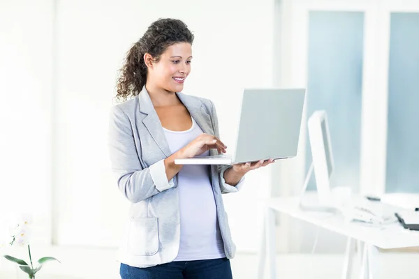 Schwangere Geschäftsfrau benutzt Laptop — Stockfoto