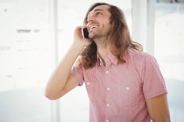 Hipster lacht tijdens het gebruik van mobiele telefoon — Stockfoto