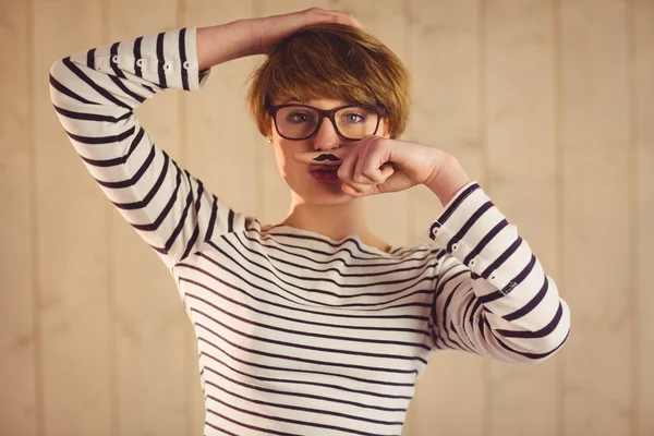 Pretty hipster with mustache on finger — Stock Photo, Image