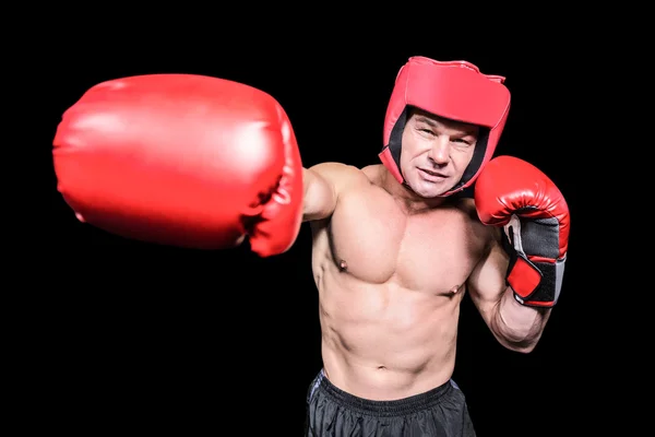 Boxeador golpeando contra fondo negro — Foto de Stock