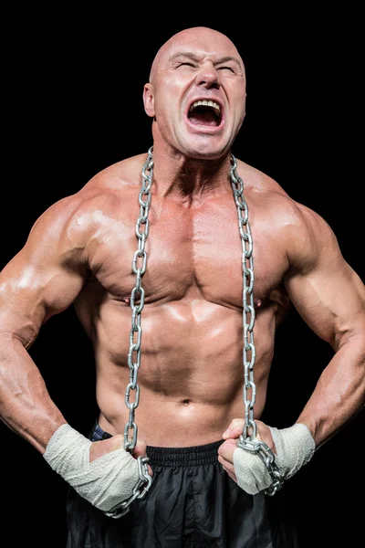 Muscular hombre gritando mientras flexiona el músculo —  Fotos de Stock