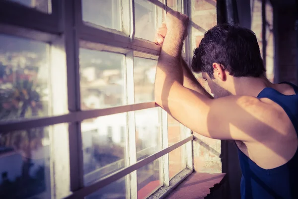 Serious man looking outside from window — Stock Photo, Image