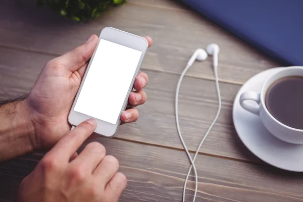 Person mit Smartphone am Schreibtisch — Stockfoto