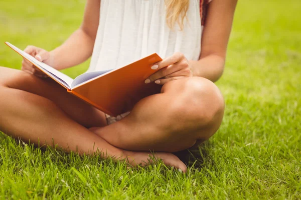Låga delen av kvinnlig student läser bok — Stockfoto