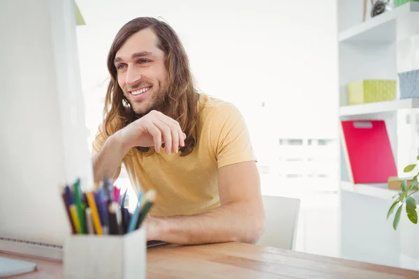 Hipster uśmiechający się podczas pracy przy biurku komputer — Zdjęcie stockowe