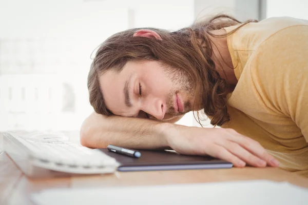 Hipster descansando cabeça na mesa do computador — Fotografia de Stock