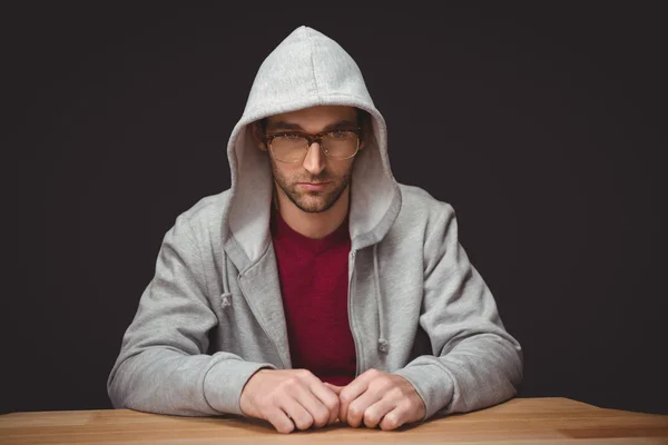 Hombre reflexivo con camisa encapuchada sentado en el escritorio —  Fotos de Stock