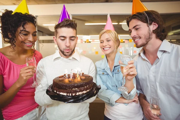 Biznesmen dmuchanie świeczki na urodzinowym torcie — Zdjęcie stockowe