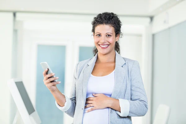 Porträtt av glada gravida affärskvinna med telefonen — Stockfoto