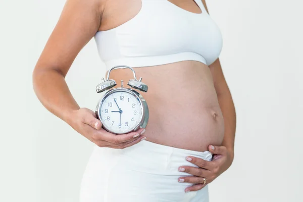 Zwangere vrouw toont klok en hobbel — Stockfoto