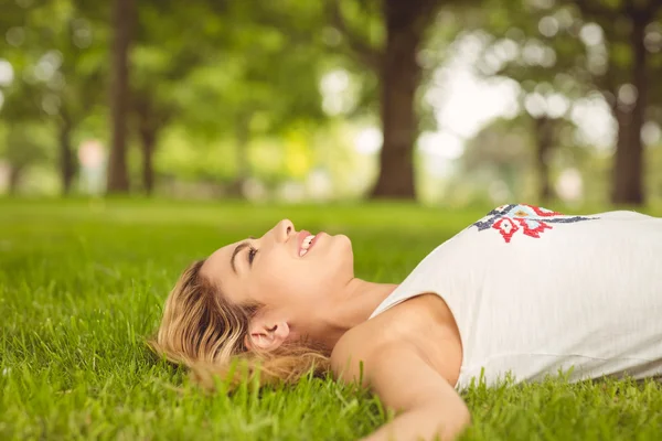 Widok z boku piękna kobieta, leżąc na trawie — Zdjęcie stockowe