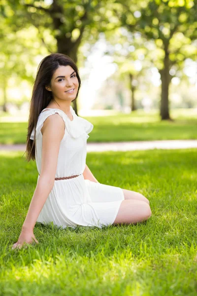 Portret van gelukkig vrouw zittend op grasland — Stockfoto