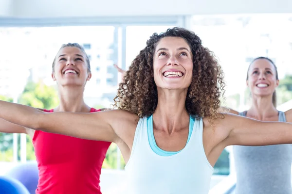 Ajustar a las mujeres mirando hacia arriba y sonriendo con los brazos extendidos — Foto de Stock