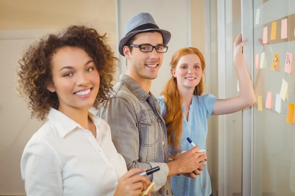 Portrait of happy business people standing by glass wall — Stock Photo, Image