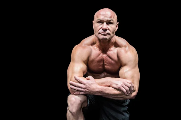 Homem muscular flexionando enquanto se ajoelha — Fotografia de Stock