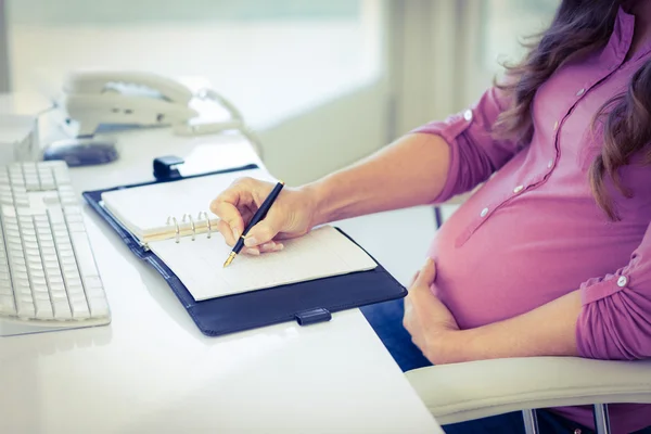 Mittelteil der Geschäftsfrau schreibt in Tagebuch — Stockfoto