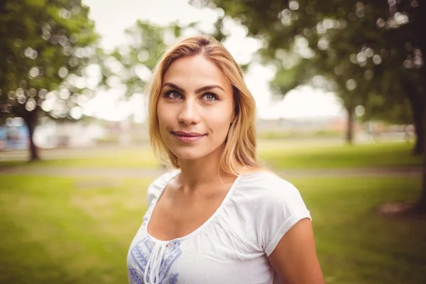 Smiling woman standing in park — Stock Photo, Image