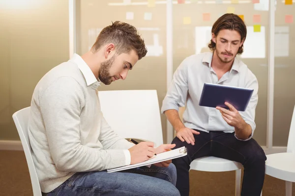 Seriöse Geschäftsleute mit digitalem Tablet und Dokument — Stockfoto