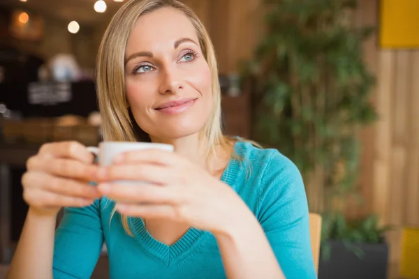 Mujer joven reflexiva sosteniendo taza de café —  Fotos de Stock