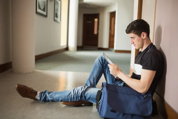 Erkek öğrenci duvar dibinde oturan dijital tablet kullanma — Stok fotoğraf