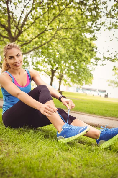 Ganzkörperporträt einer glücklichen Frau, die Schnürsenkel bindet — Stockfoto