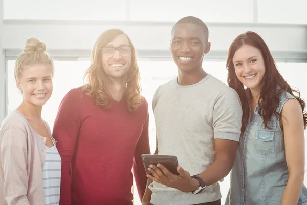 Hombre sosteniendo tableta digital con compañeros de trabajo — Foto de Stock