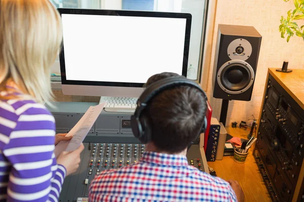 Mannelijke en vrouwelijke radio gastheren in studio — Stockfoto