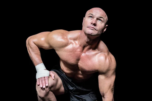 Bodybuilder exercising against black background — Stock Photo, Image