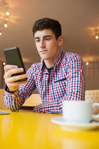 Nízký úhel pohledu mladého muže, pomocí mobilního telefonu — Stock fotografie