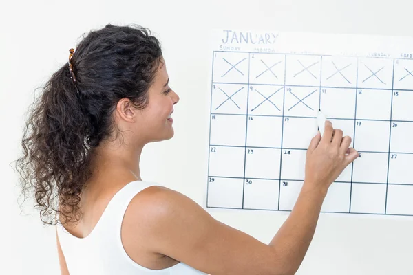 Mujer embarazada marcando las fechas en el calendario — Foto de Stock