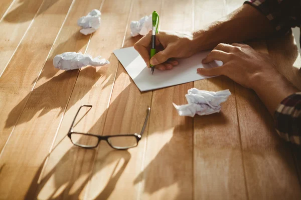 Hipster writing on paper at desk in office — Stock Photo, Image