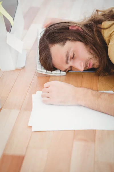 Trött hipster vilar huvudet på datorns tangentbord — Stockfoto