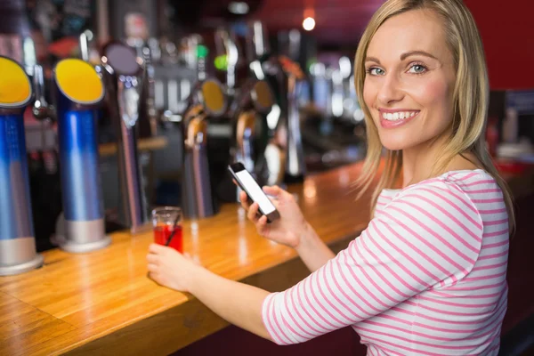 Mujer con teléfono móvil celebración de vidrio — Foto de Stock