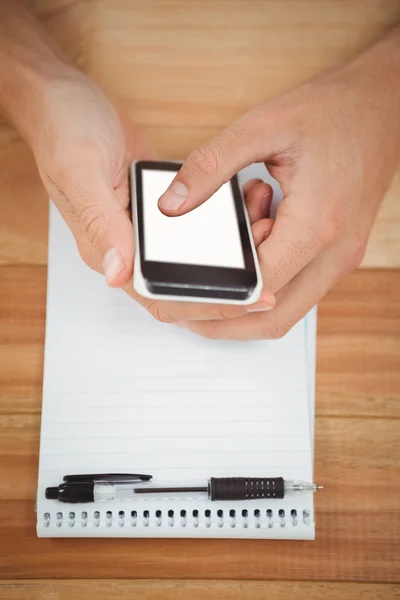 Man met smartphone met Kladblok op tabel in office — Stockfoto