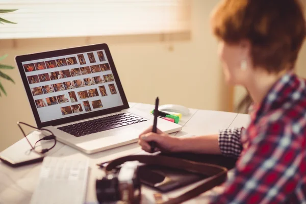 Fokussierte Fotografin sucht Bilder auf ihrem Computer — Stockfoto