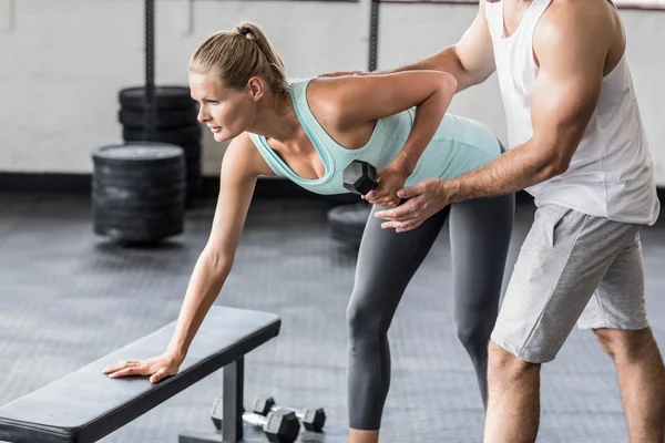 Personal trainer aiutare il cliente a sollevare i manubri — Foto Stock